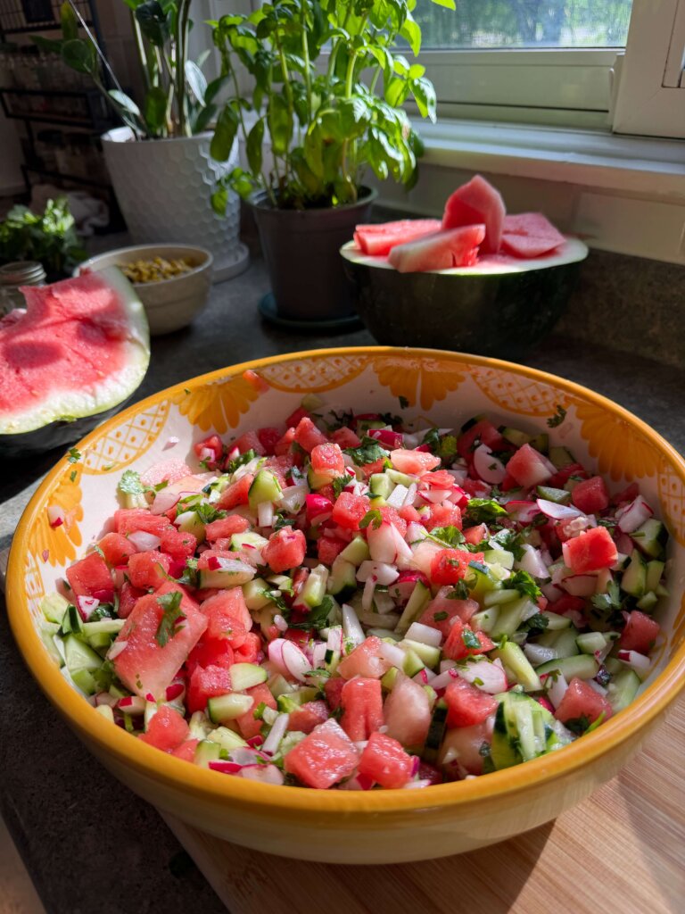 watermelon salad on counter next to chopped watermelon
